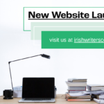 Photo of a desk with laptop and books. text above reads 'New Website Launch'